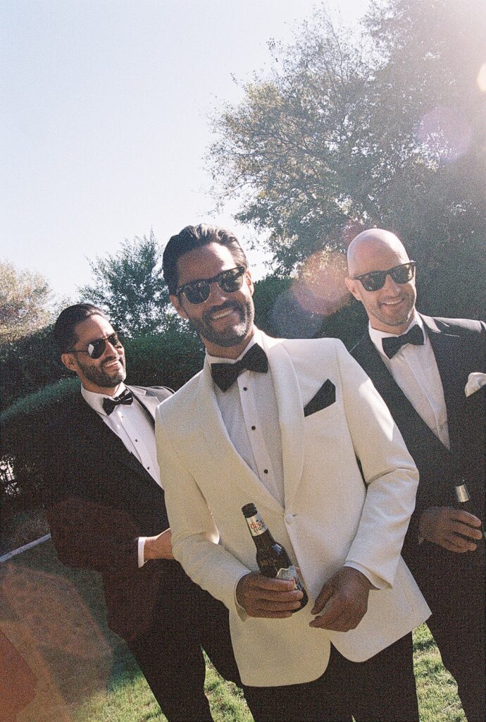 groom walking and drinking beer with his groomsmen