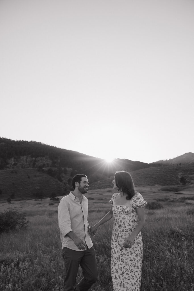 couple walking in open field in fort collins during their colorado engagement