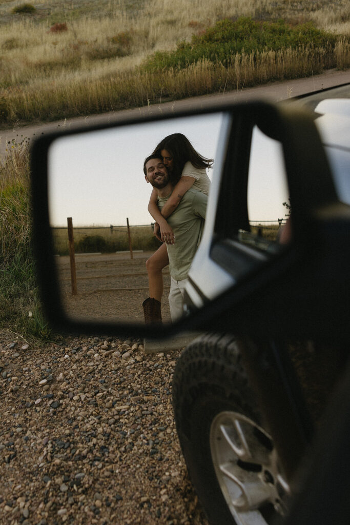 couple standing in open field in front of their truck in fort collins during their colorado engagement