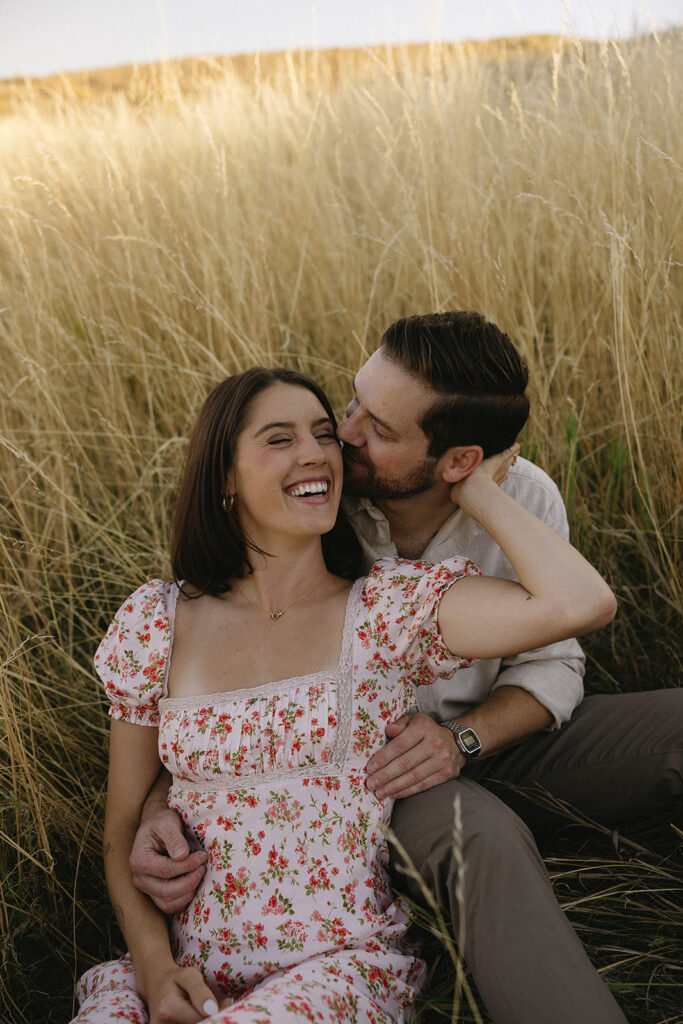 couple sitting in open field in fort collins during their colorado engagement