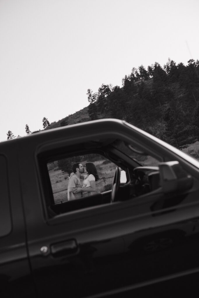 couple standing in open field in front of their truck in fort collins during their colorado engagement