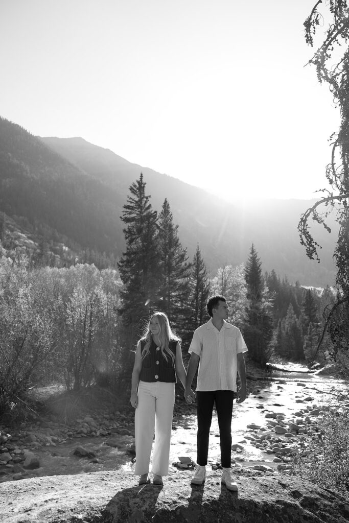 couple holding hands with each other in aspen surrounded by trees