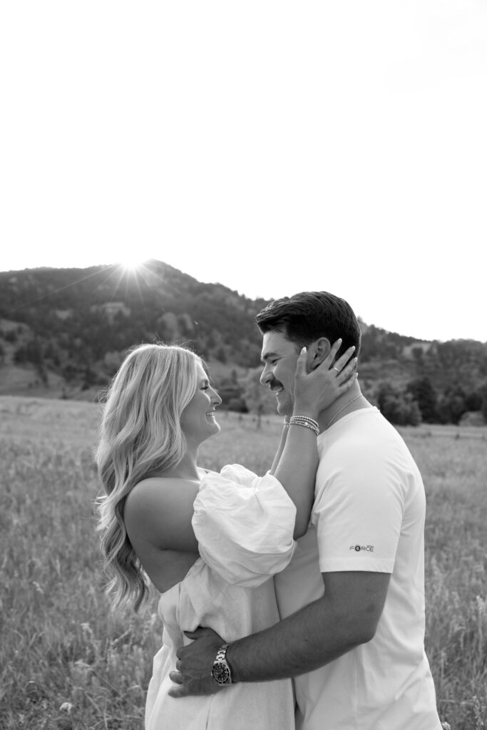 couple holding each other in open field at boulder 