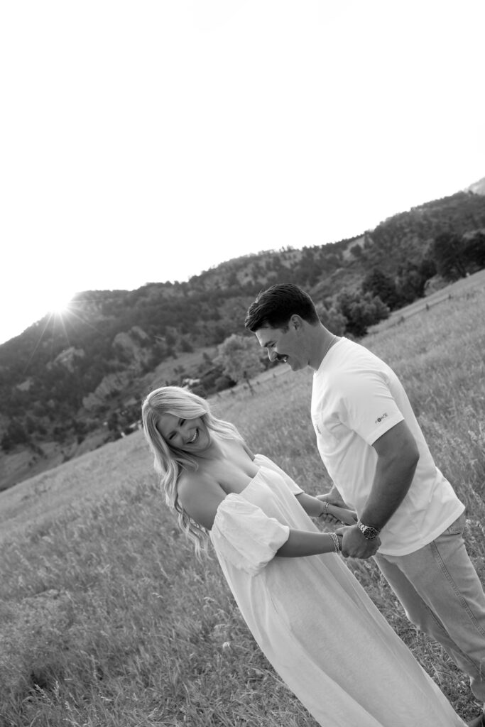 couple holding hands in open field at boulder during their colorado engagement