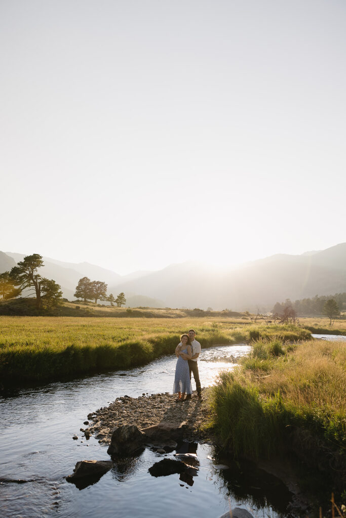 couple standing on rocks at rocky mountain national park during their colorado engagement