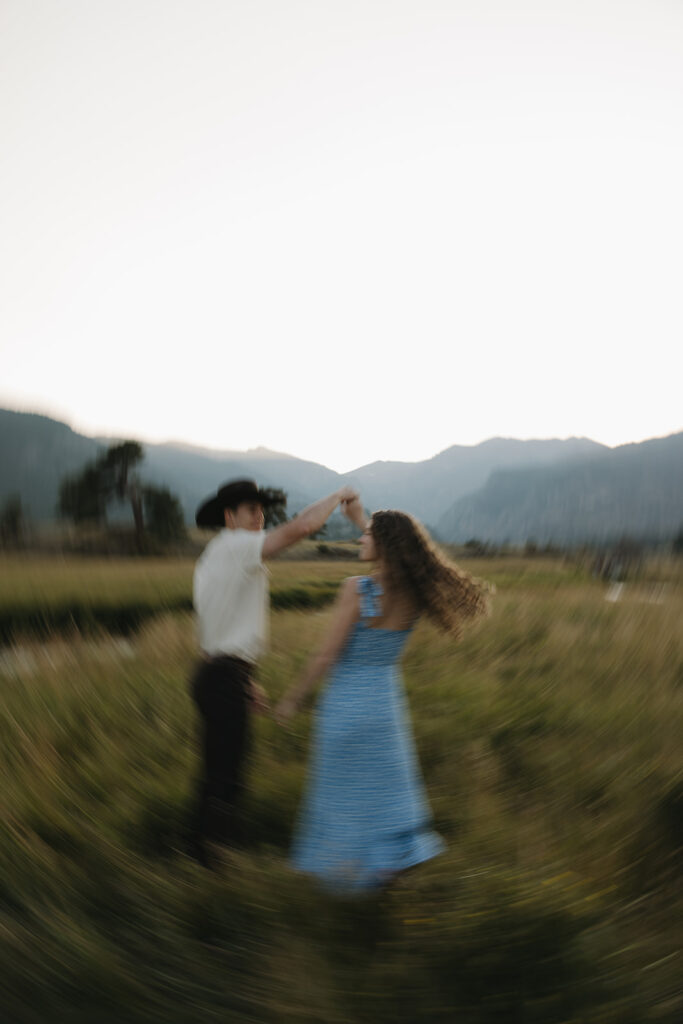 couple dancing in open field at rocky mountain national park during their colorado engagement