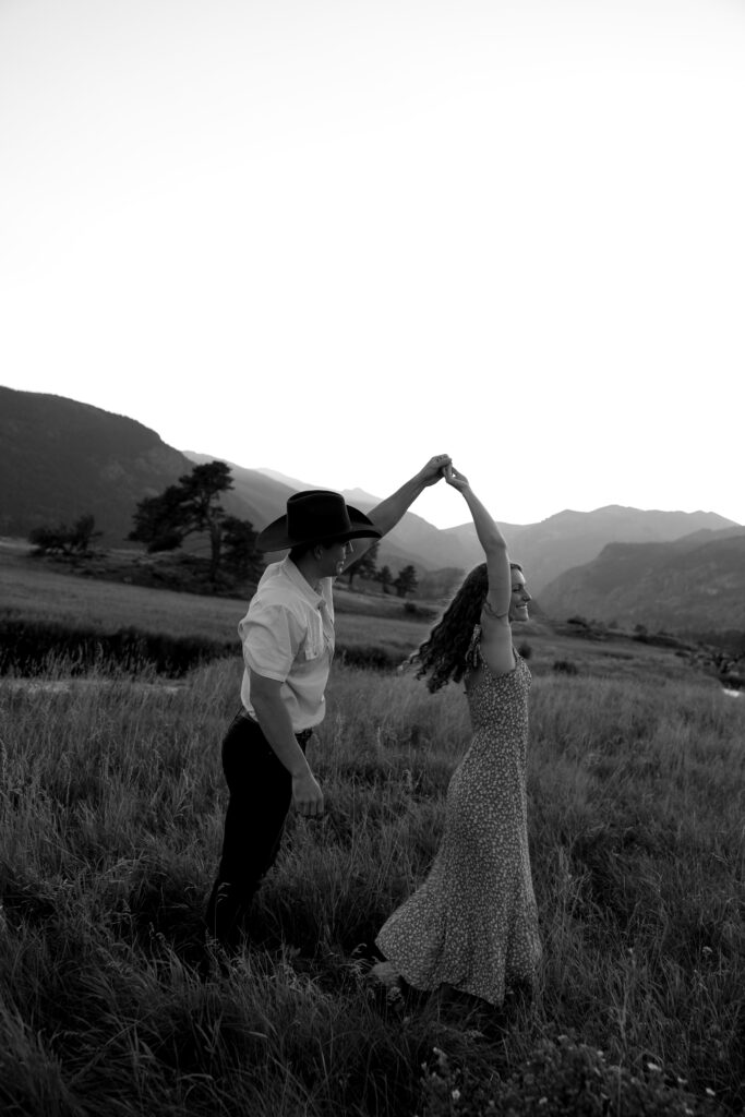 couple dancing in open field at rocky mountain national park during their colorado engagement