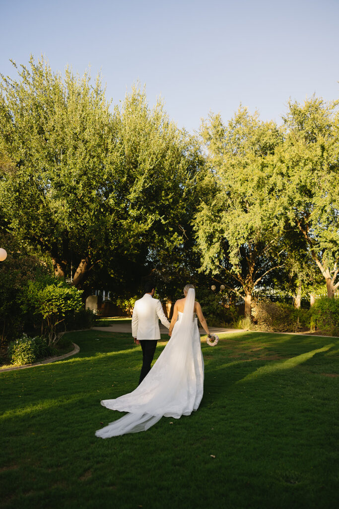 A luxe timeless wedding day in Scottsdale Arizona with bride and groom holding hands walking togther after ceremony