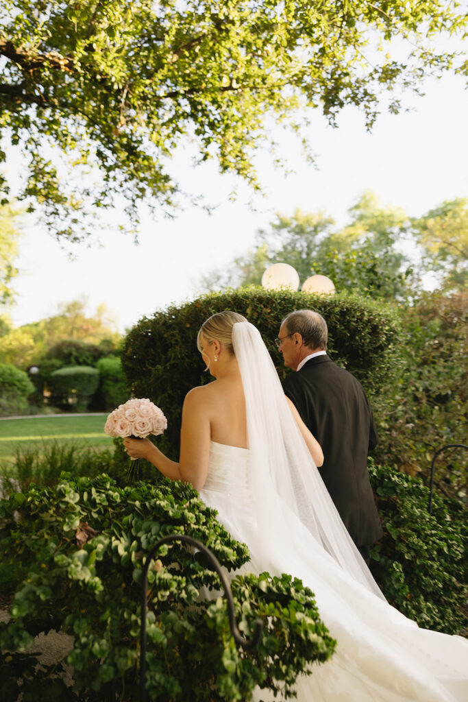 bride being walked by her dad on her way to ceremony