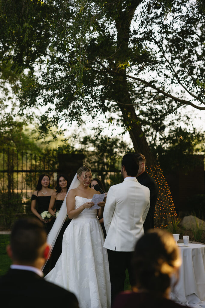 bride reading wedding vows to groom in garden inspired wedding ceremony design