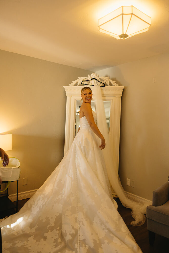 A luxe timeless wedding day in Scottsdale Arizona with bride posing in a photo in her dress