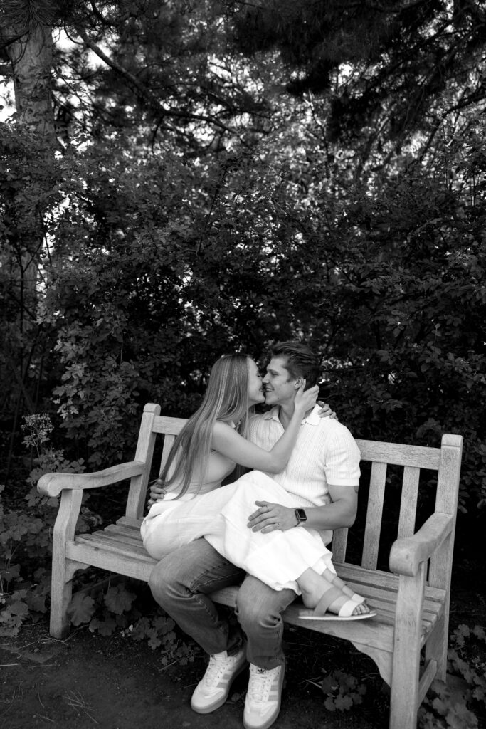 couple sitting on bench at denver botanical gardens during their colorado engagement