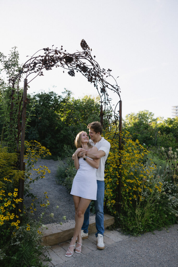 couple standing in front of the garden  at denver botanical gardens during their colorado engagement