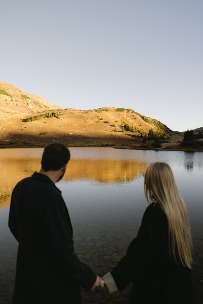 couple holding hands during their colorado engagement photos at loveland pass