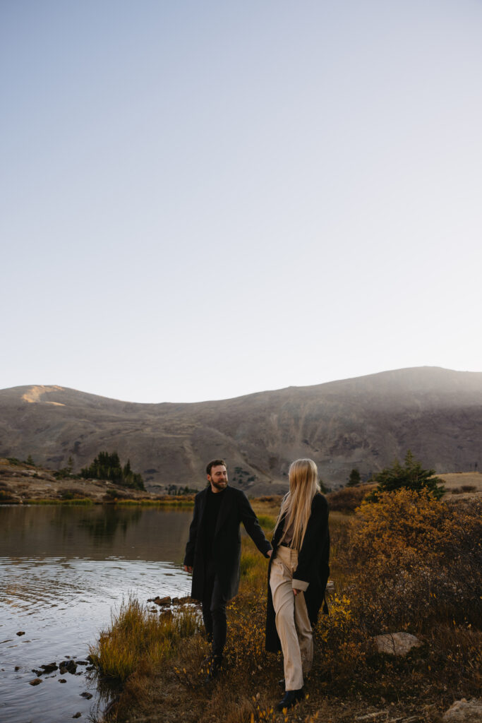 couple walking with each other during engagement photos at loveland pass