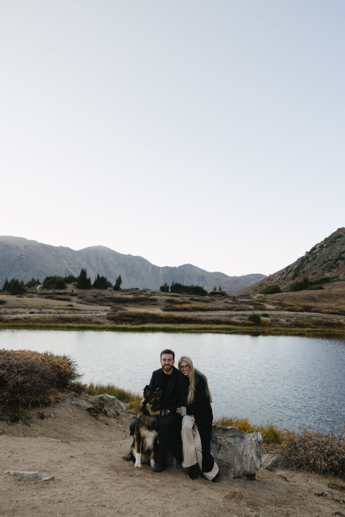 couple holding each other with their dog during engagement photos