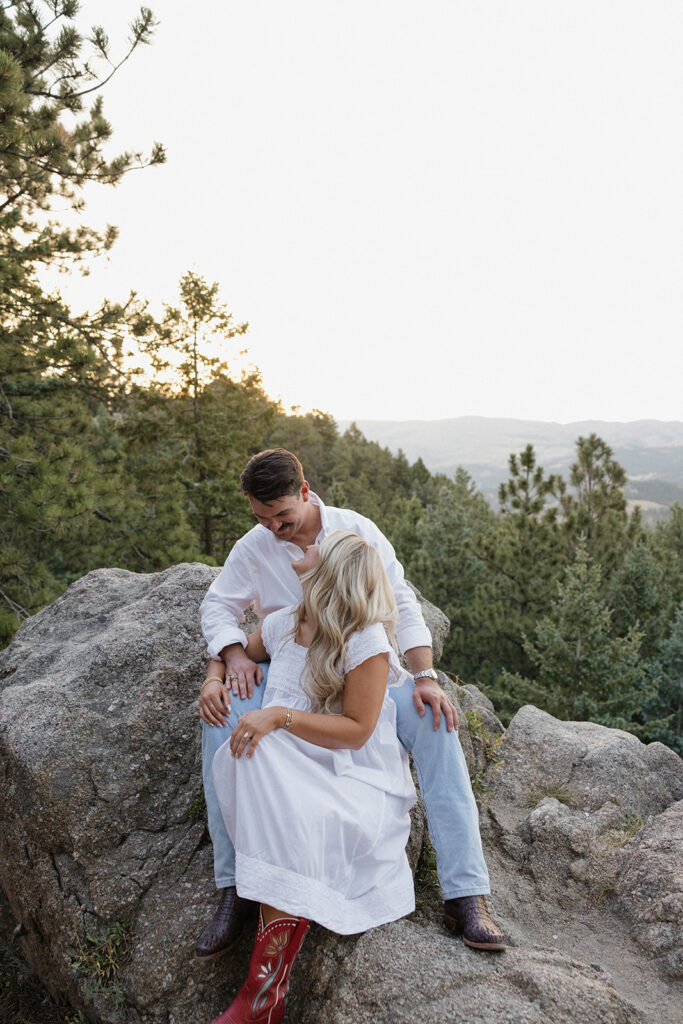 couple sitting on rock in boulder during engagement session