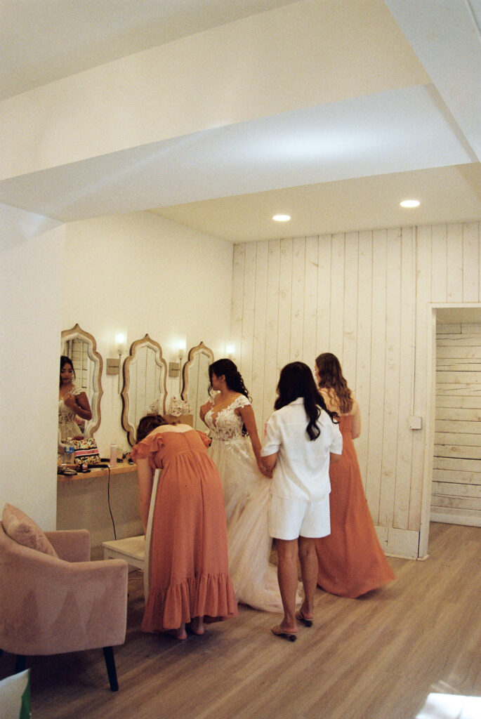 bride with her bridesmaids getting ready captured on film photography