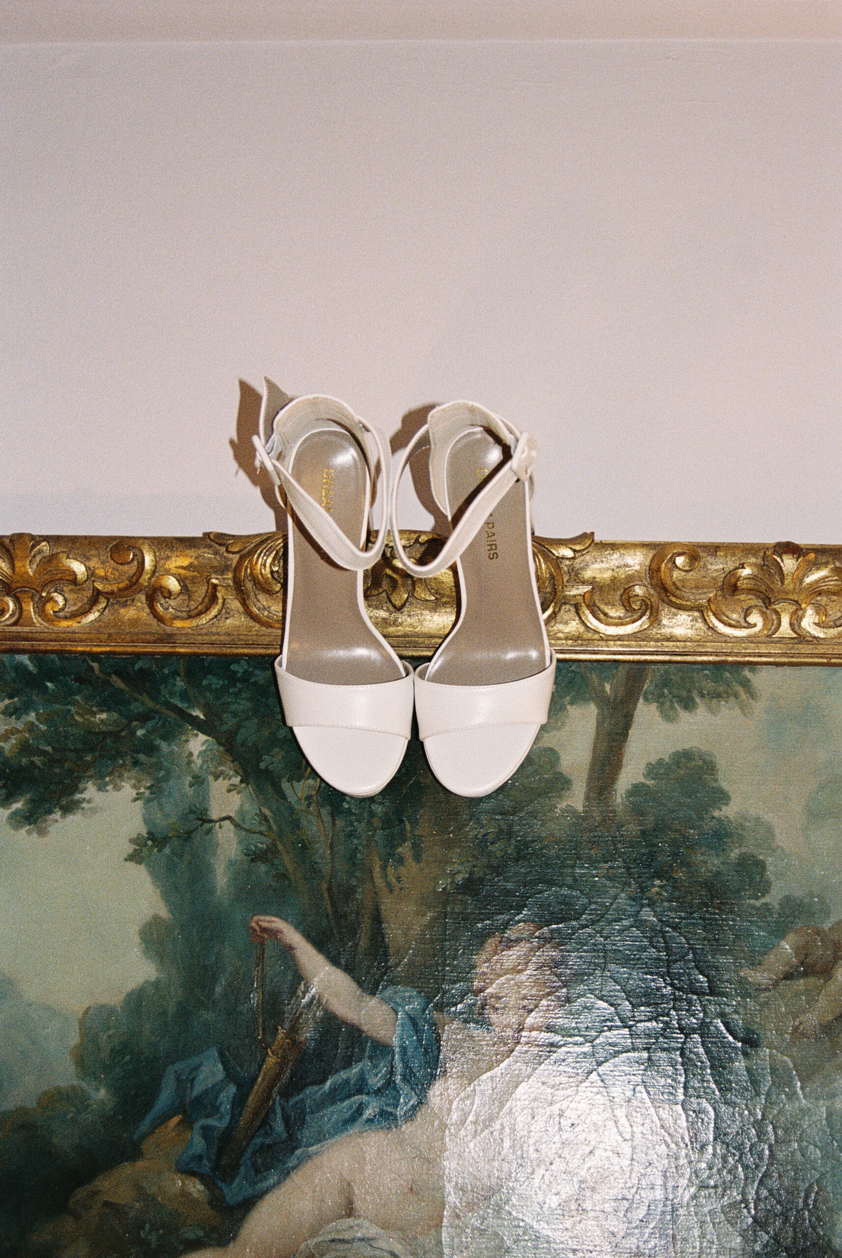 wedding shoes hanging from picture during film photography 