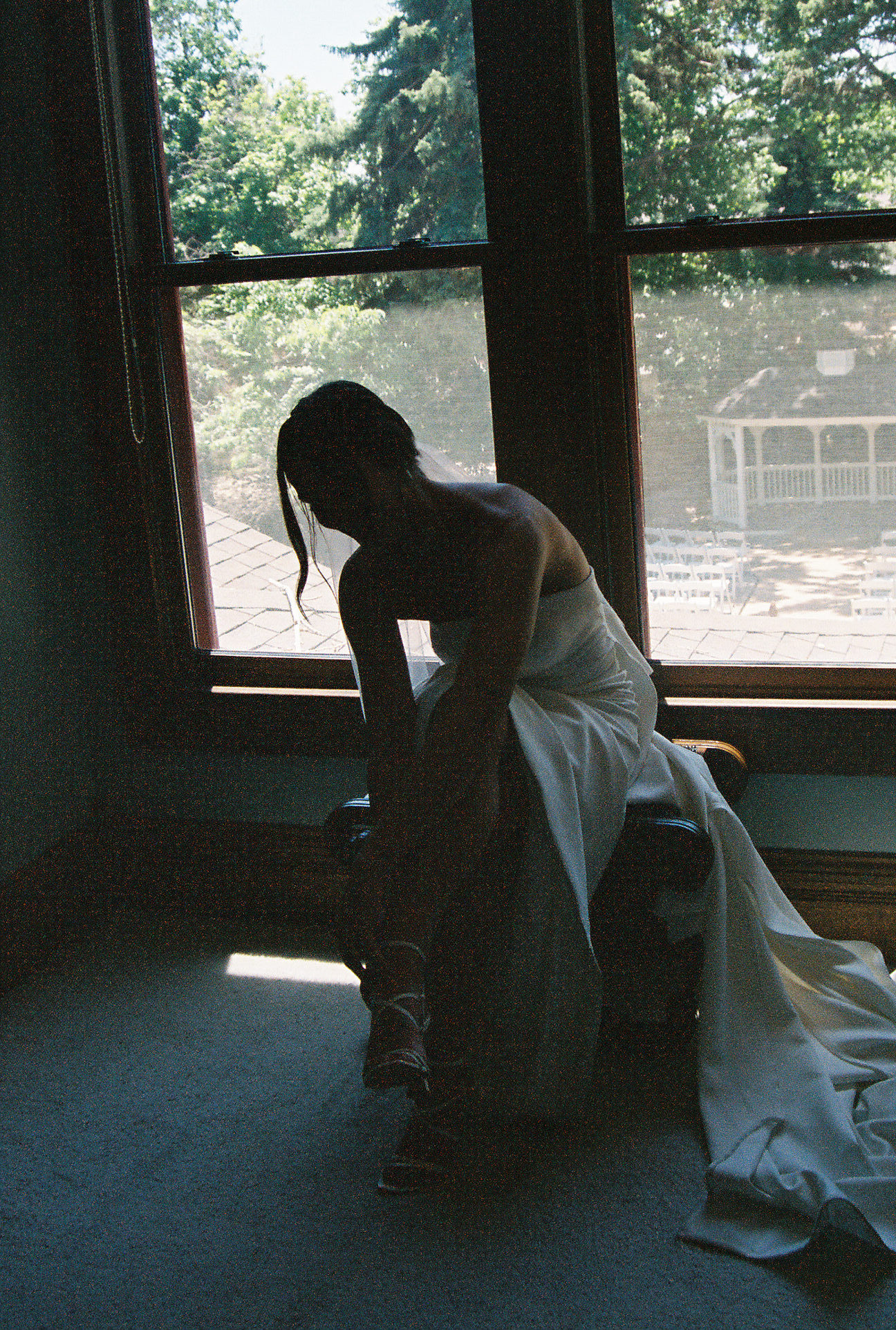 bride putting on her wedding shoes captured on film photography