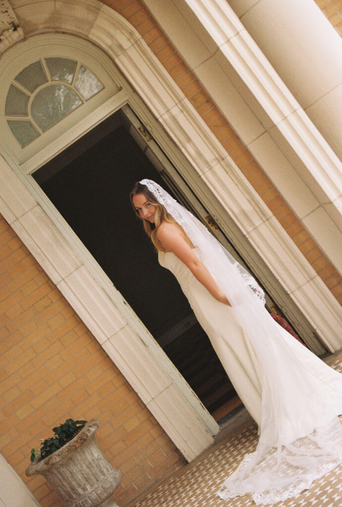 bride walking through her venue wearing her wedding dress captured on film photography