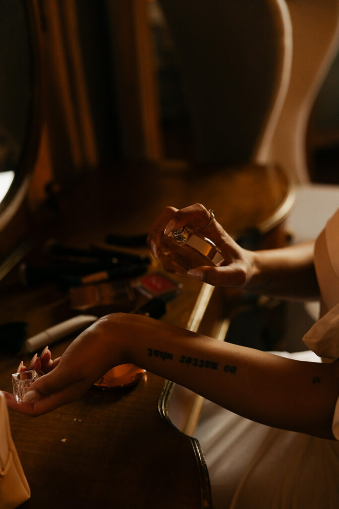 close up photo of bride spraying her wedding day perfume