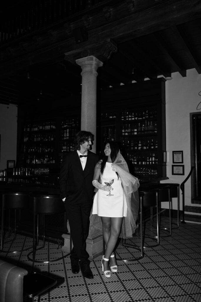 bride and groom sharing a drink in a bar