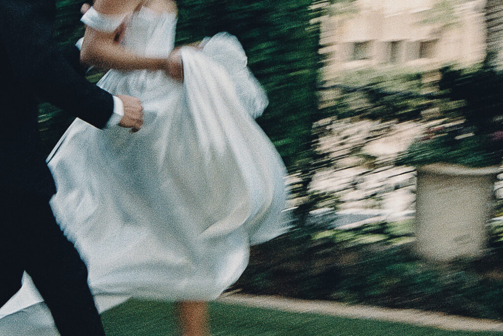 film photo of bride and groom frolicking around the wrigley mansion