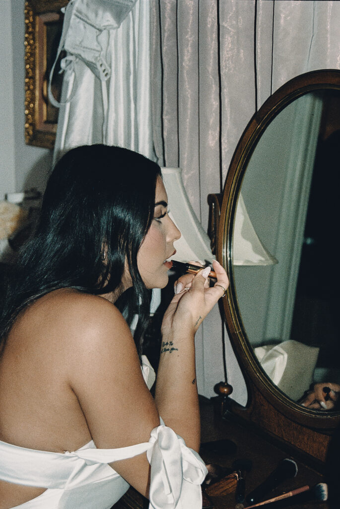 bride putting on her makeup before walking out to her wedding ceremony