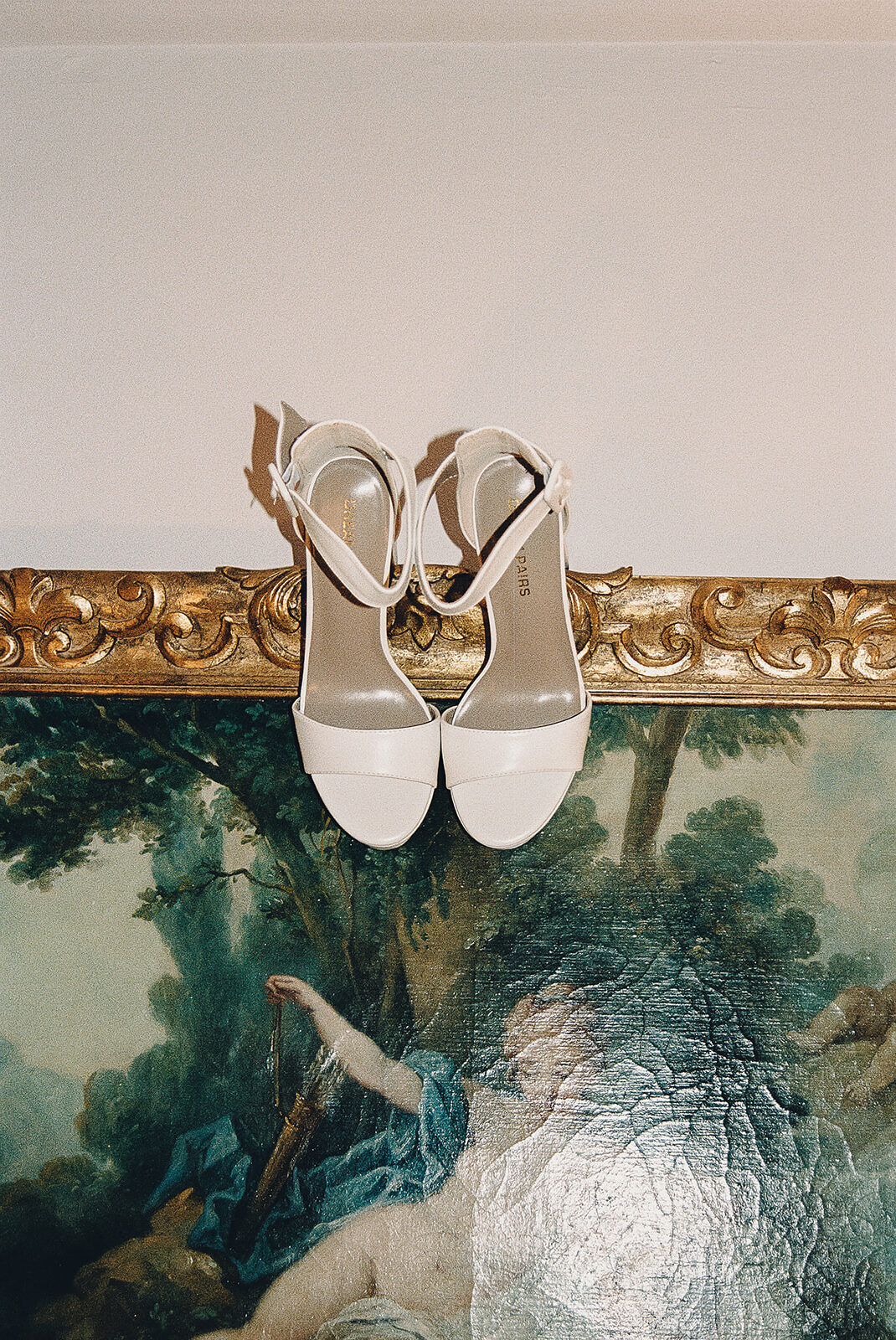 detail film photo of brides shoes on a vintage painting