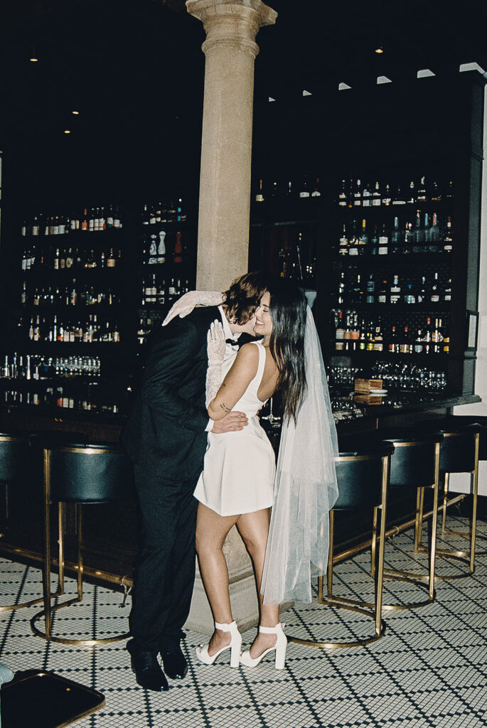 film photo of groom kissing brides cheek and neck after their wedding day