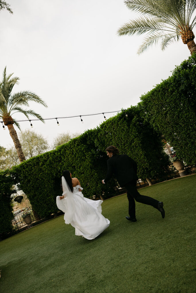 bride and groom chasing eachother around the garden of the wrigley mansion venue