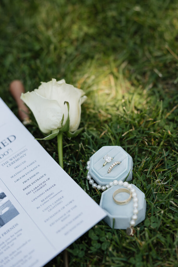 photo of wedding rings and invites during wedding detail photos