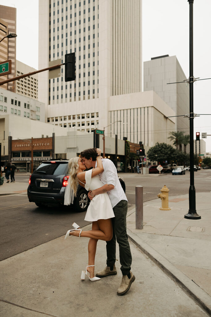 couple kissing during downtown phoenix engagement photos 