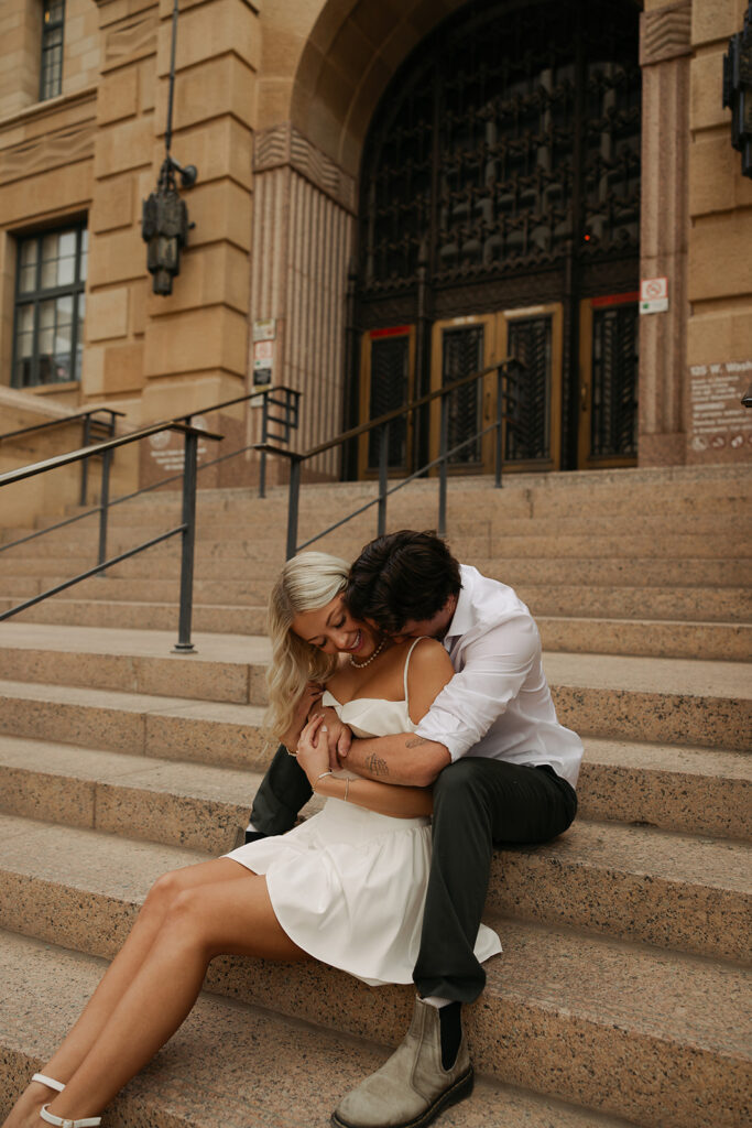 couple sitting on stairs during downtown phoenix engagement photos 