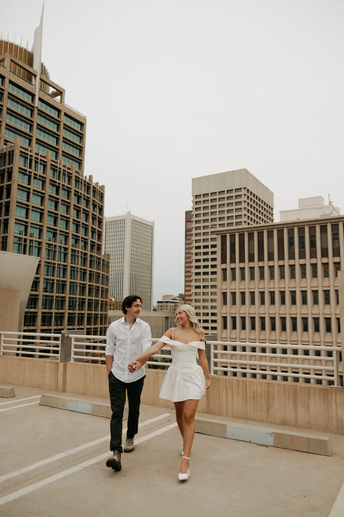 couple walking together on rooftop during couples session