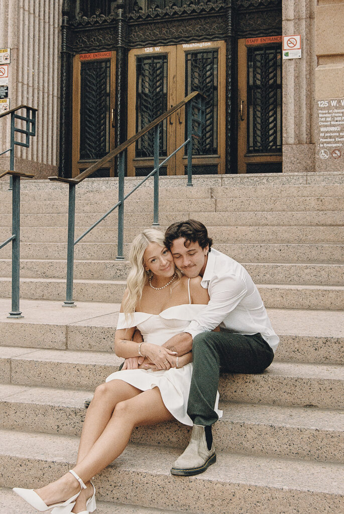 film photo of couple sitting on steps during engagement session