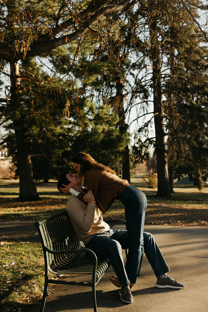 couple sitting on park bench with each other at cheesman park in denver