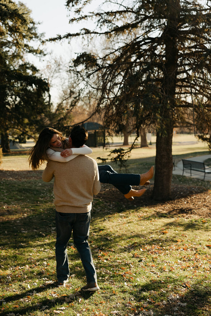 couple being playful at cheesman park in denver during their colorado engagement photos