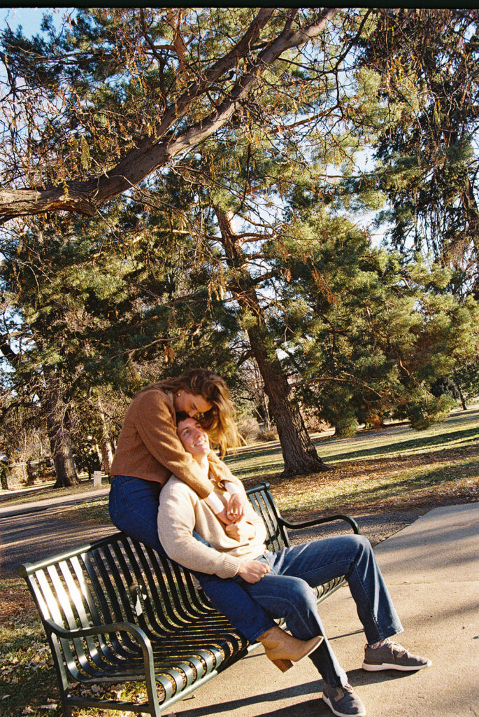 film photo of couple sitting on bench at park during couples session