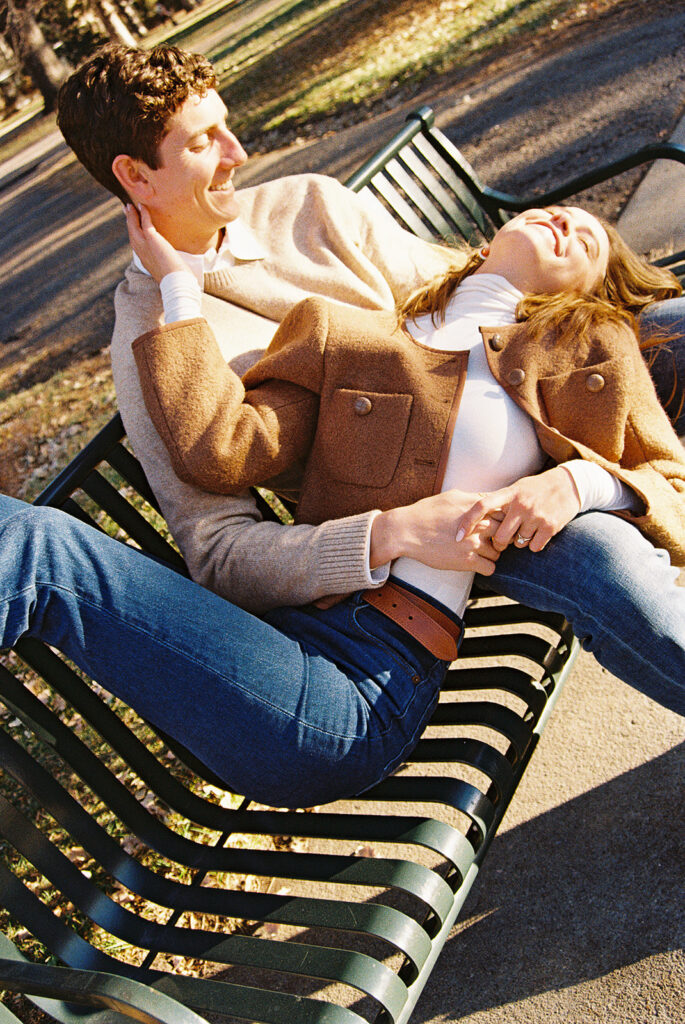 film photo of couple sitting on bench at park during couples session