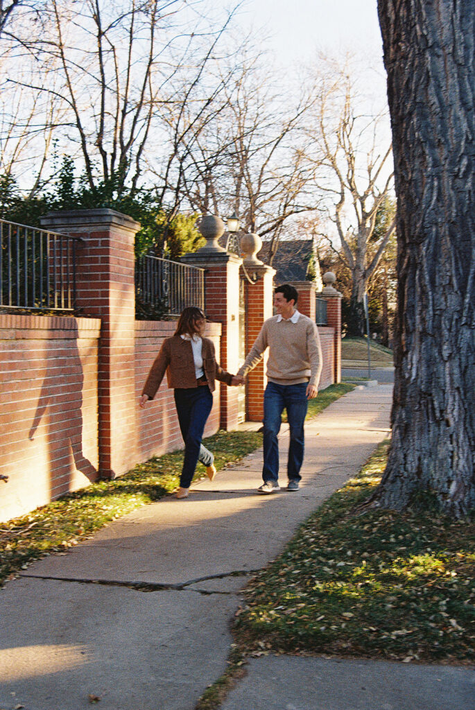 film photo of couple walking holding hands with each other at park during couples session