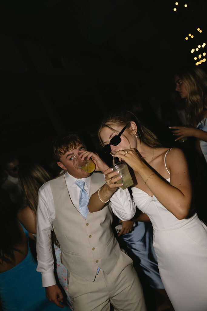 bride and groom linking arms and taking a drink