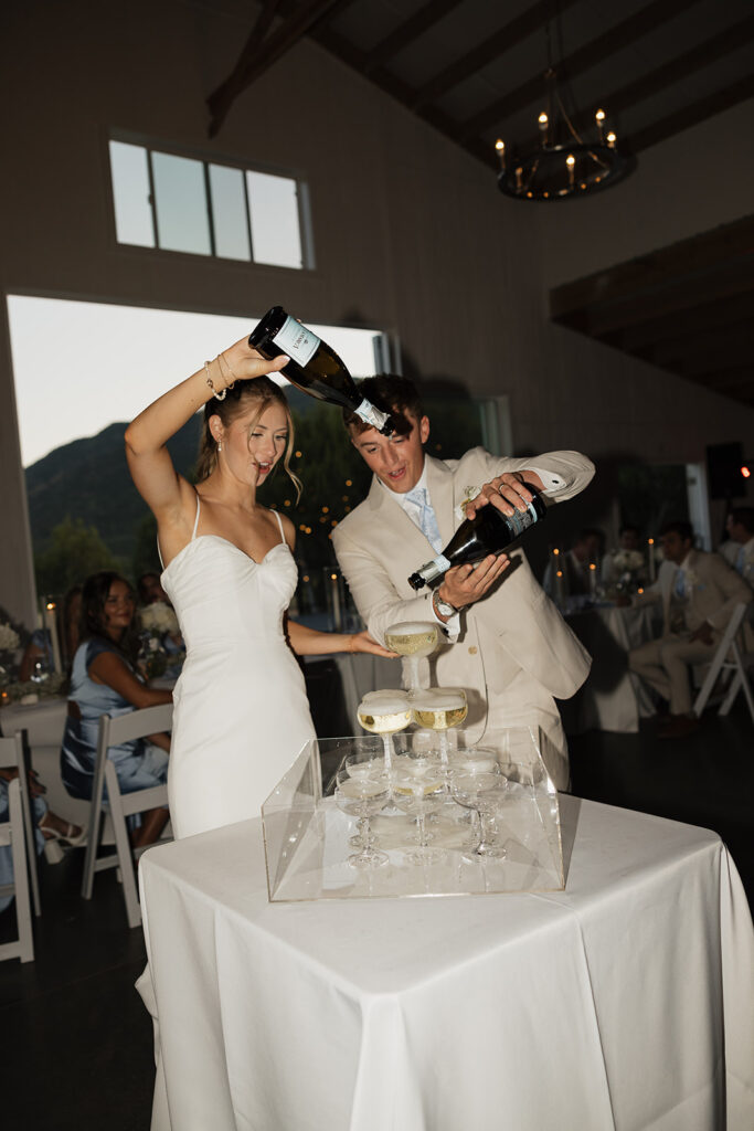 bride and groom pouring champagne into a champagne tower