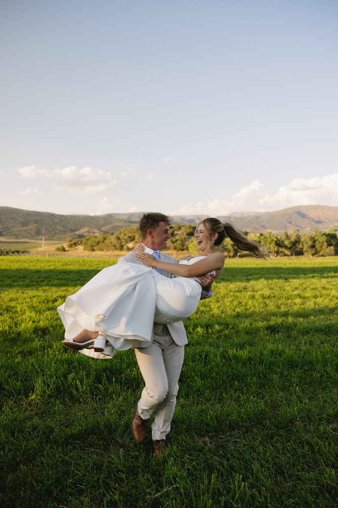 bride and groom portraits on wedding day spinning around in the grass