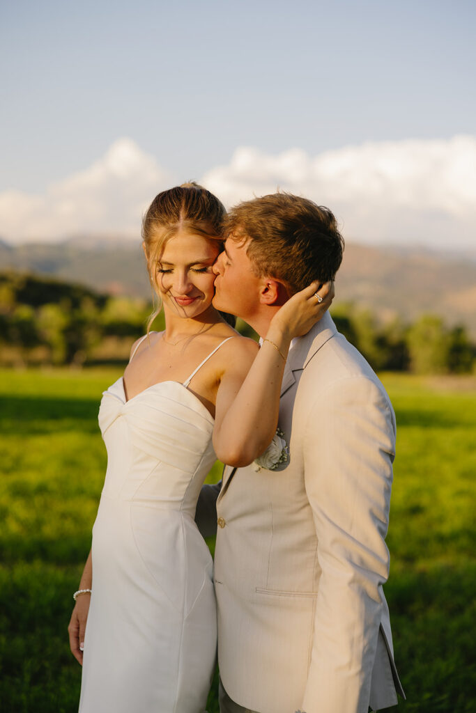 picture of the groom kissing the bride on the cheek