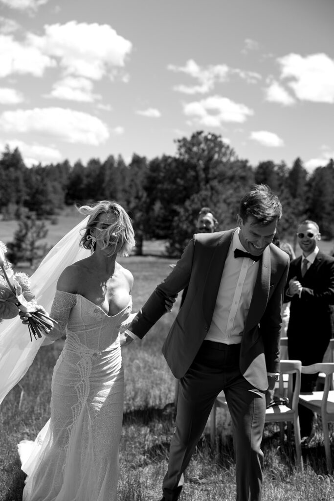 bride and groom walking back down the aisle together after ceremony at greystone castle boulder