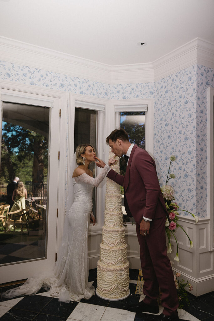 bride and groom eating their wedding cake together at greystone castle boulder