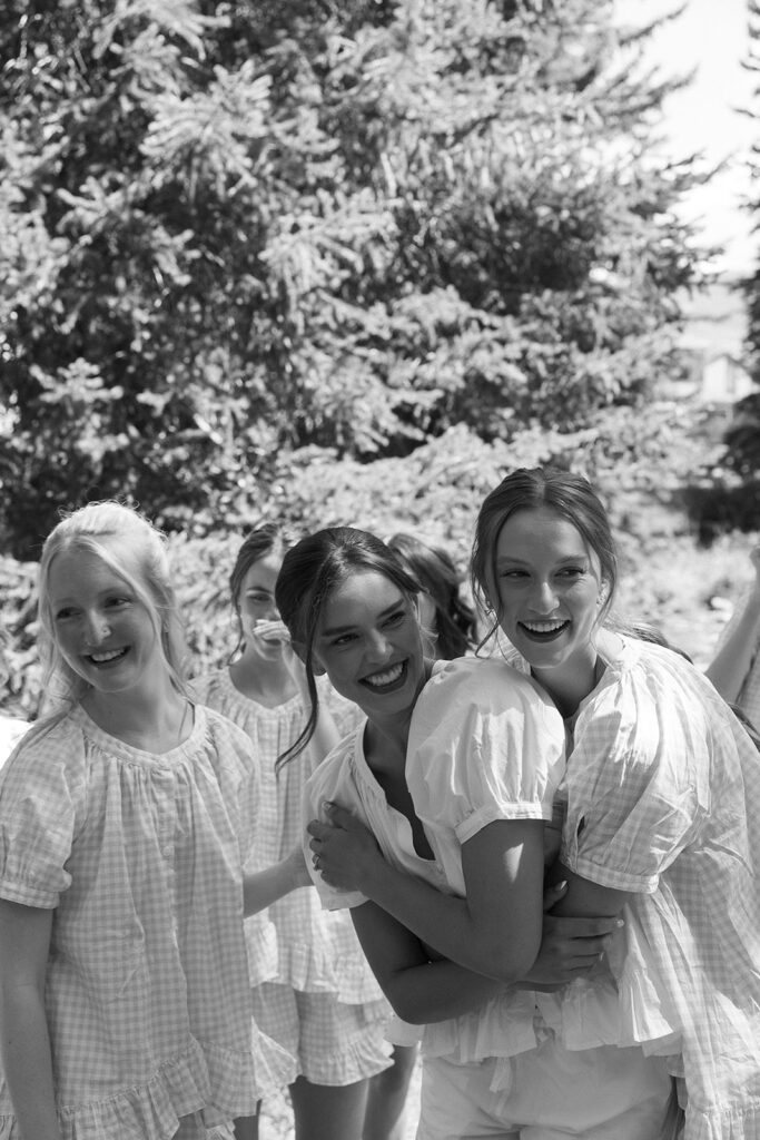 bride hugging bridesmaids documentary style wedding photos