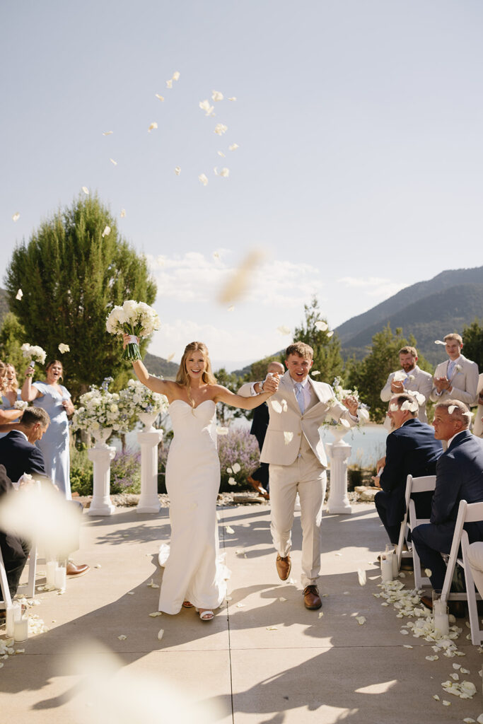 bride and groom celebrating walking back down the ails with flower petals